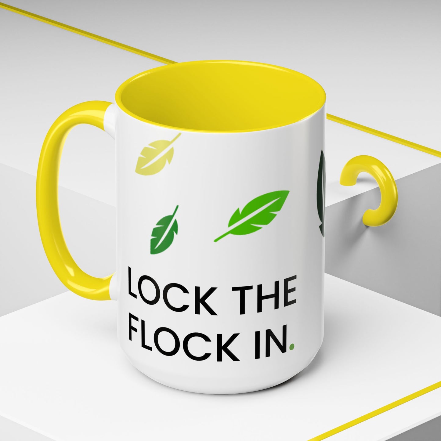 White mug with yellow interior and handle, featuring green feathers and text on a white background.